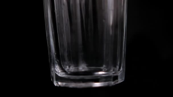 Powoli wrzucając kostki lodu do pustej szklanki — Wideo stockowe