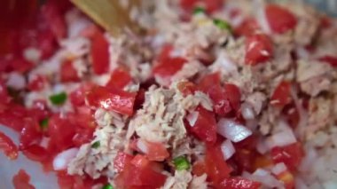 Tahta kaşık, dilimlenmiş ton balığı ve Meksika pico de gallo karışımı.