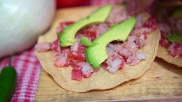 Tostadas mexicanas de atún sobre tabla de madera y rodeadas de verduras — Vídeos de Stock