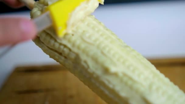 Hand sprida majonnäs på majs ovanför trä skärbräda — Stockvideo