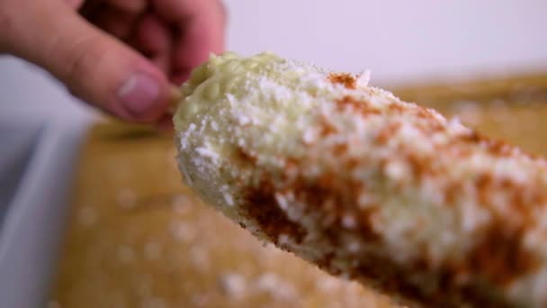 Espolvorear a mano chile en polvo sobre maíz sobre tabla de cortar de madera — Vídeos de Stock