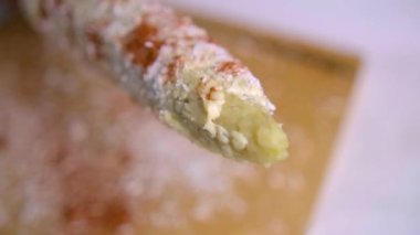 Tahta kesme tahtasının üzerinde mısır tozu serpiyorum.