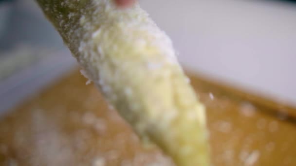 Ręcznie kropiący ser na kukurydzy nad drewnianą deską do krojenia — Wideo stockowe
