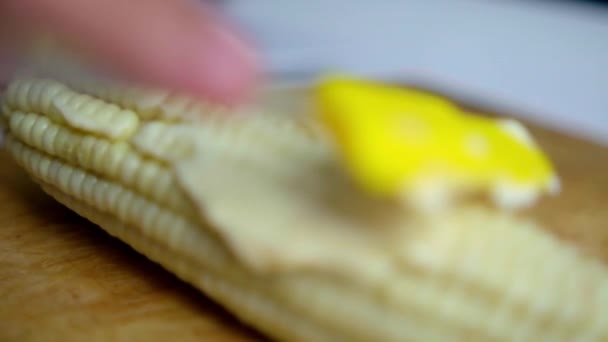 Tangan menyebarkan mayones di jagung di atas papan potong kayu — Stok Video