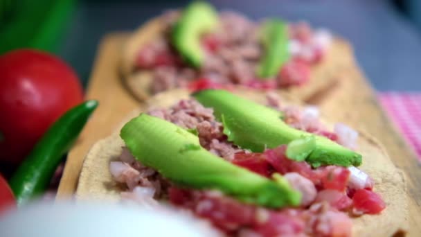 Mexicaanse tonijn tostadas op houten plank en omgeven door groenten — Stockvideo