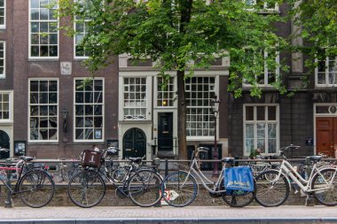 Banliyö binalarının önündeki kaldırıma park edilmiş bisiklet sıraları.