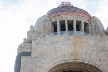 Hafifçe bulutlu mavi gökyüzünün altında Devrim anıtı