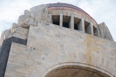 Hafifçe bulutlu mavi gökyüzünün altında Devrim anıtı