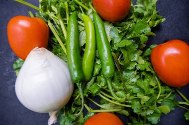 Biber, soğan ve kişniş üzerine domates.