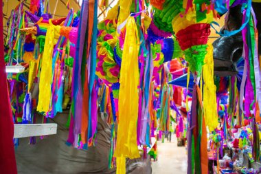Markette asılı kağıt şeritli renkli pinatalar.