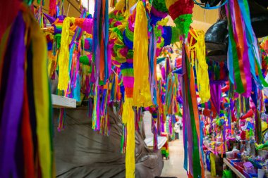 Markette asılı kağıt şeritli renkli pinatalar.