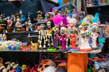 Siyah yüzeyde gösterilen renkli el yapımı iskelet figürleri