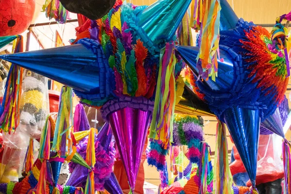 Markette asılı kağıt şeritli renkli pinatalar.