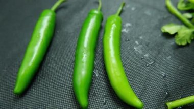 Siyah masanın üzerinde kırmızı biber ve kişniş resmi.