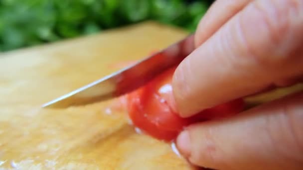 Mãos cortando um tomate em uma tábua de corte — Vídeo de Stock