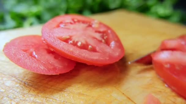 Mãos cortando um tomate em uma tábua de corte — Vídeo de Stock