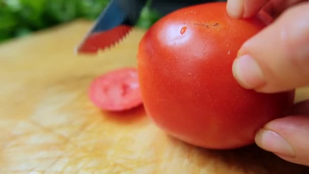 Руки нарізають помідор на обробній дошці — стокове відео