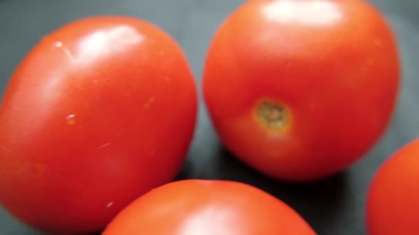 Koyu mavi bir masada taze domateslerin yakın çekimi. — Stok video