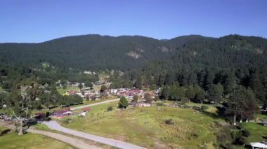 Küçük bir kasaba ve uzak dağları olan bir orman.