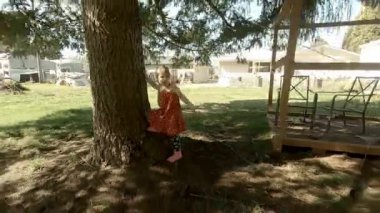 Büyük arka bahçedeki ahşap yapıda oynayan sevimli küçük kız.