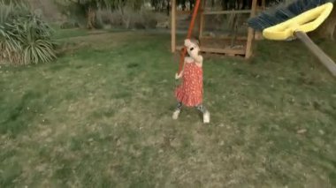 Sevimli küçük kız büyük arka bahçede süpürgeyle oynuyor.