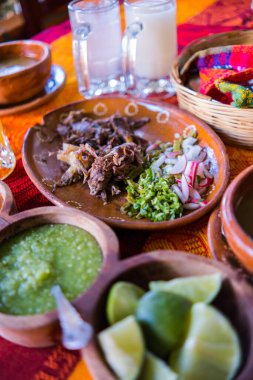 Meksika usulü kuzu eti, sos ve iki kavanoz ferahlatıcı içecek.
