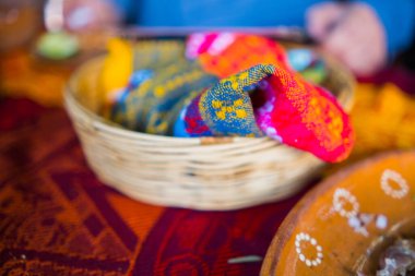 Kırmızı ve turuncu masa örtüsünün üstündeki sepetin içinde sanatsal tortilla peçetesi