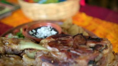 Kızarmış et, sebze ve renkli masa örtüsü üzerinde yeniden kızartılmış fasulye.