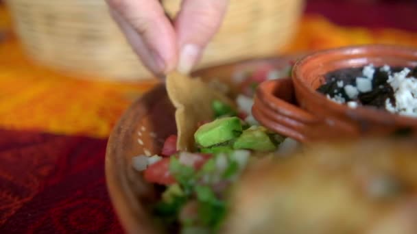 Hand taucht Tortilla Chip in Teller mit traditionellem Pico de Gallo — Stockvideo