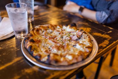 Lezzetli peynirli pizza ve bir bardak su.