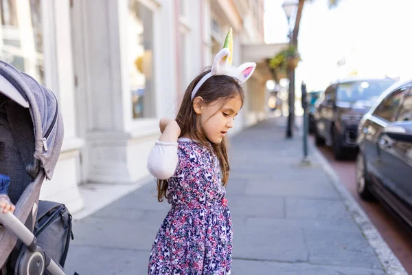 Очаровательная маленькая девочка на улице в повязке единорога — стоковое фото