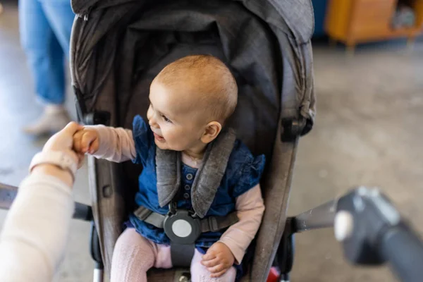 Adorável bebê feliz em um carrinho de bebê cinza no restaurante — Fotografia de Stock