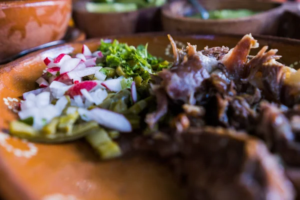 Mexican chopped lamb meat, hot sauces, and lime slices in clay bowls — Stock Photo, Image