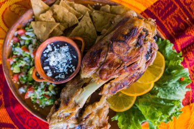 Kızarmış et, sebze ve renkli masa örtüsü üzerinde yeniden kızartılmış fasulye.