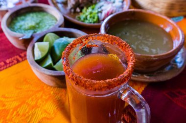 Bulanık arka planlı cam bardakta geleneksel Meksika Michelada 'sı.