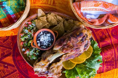 Kızarmış et, sebze ve renkli masa örtüsü üzerinde yeniden kızartılmış fasulye.