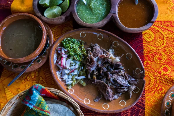 Mexican chopped lamb meat, hot sauces, and tortillas on colorful tablecloth — Stock Photo, Image