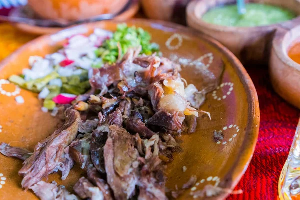 Mexican chopped lamb meat, hot sauces, and lime slices in clay bowls — Stock Photo, Image