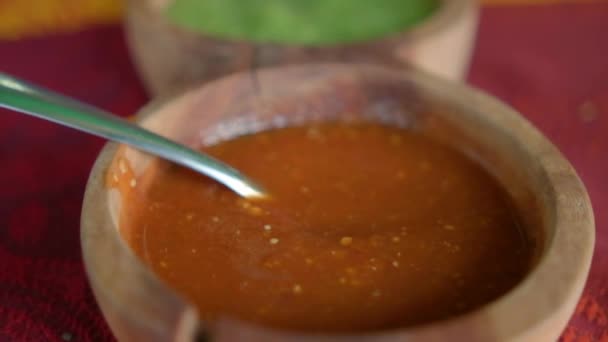 Houten schalen van hete sauzen en limoenschijfjes boven kleurrijk tafelkleed — Stockvideo