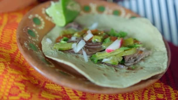 Meksika kuzu taco 'su ve renkli masa örtüsünün üstünde sıcak soslar. — Stok video