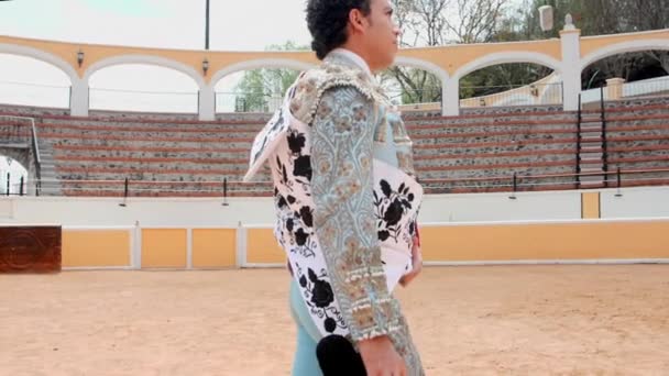 Bullfighter v modrém obleku světel pomalu kráčí v býčí aréně — Stock video