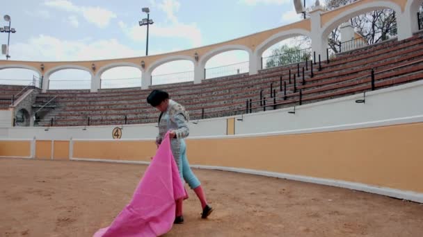 Bullfighter pomalu mává pláštěm v prázdném býčím ringu — Stock video