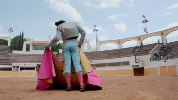 Bullfighter pomalu mává pláštěm v prázdném býčím ringu — Stock video