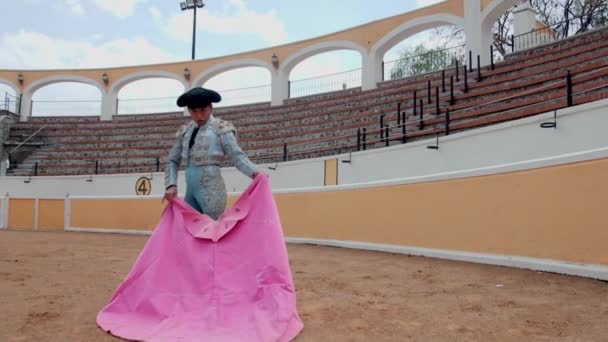 Bullfighter pomalu mává pláštěm v prázdném býčím ringu — Stock video