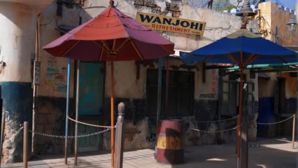 Edificios con antigua arquitectura keniata y coloridos paraguas detrás de la pared — Vídeo de stock