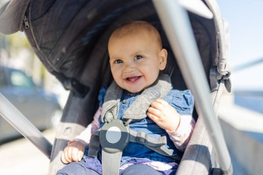 Gri bebek arabasındaki sevimli mutlu bebek. Geçmişi bulanık.