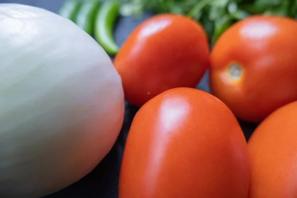 Chili paprika 's, ui en een tomaat boven koriander — Stockfoto