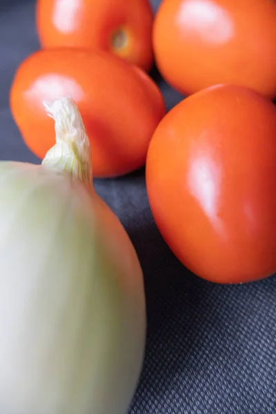 Tomates y cebolla sobre mesa azul oscuro — Foto de Stock