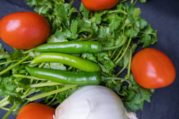 Chili paprika 's, ui en een tomaat boven koriander — Stockfoto
