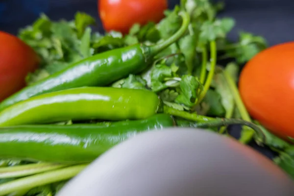 Chili paprika 's, ui en een tomaat boven koriander — Stockfoto